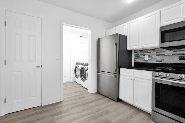 4899 Common Market Pl, Dublin, OH 43016 - kitchen featuring stainless steel appliances, washing machine and dryer, light wood-style flooring, white cabinets, and tasteful backsplash