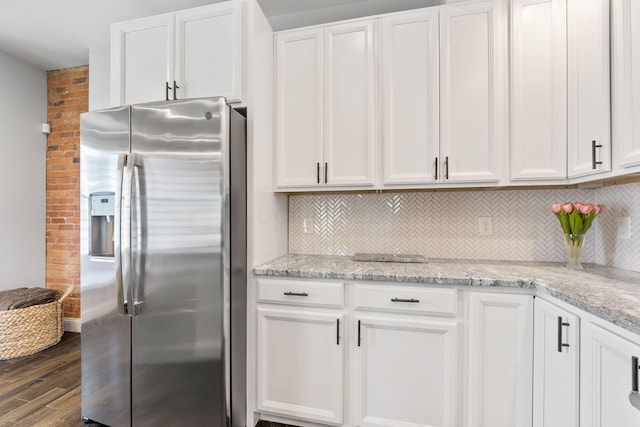 kitchen with dark wood finished floors, light stone countertops, stainless steel fridge with ice dispenser, backsplash, and white cabinetry