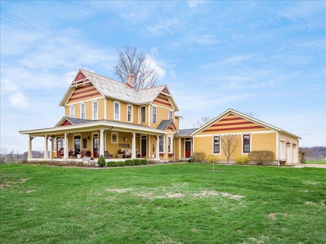 view of front of property with an attached garage, a front lawn, and a chimney