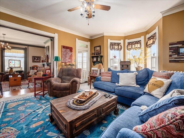 living area featuring ceiling fan with notable chandelier, plenty of natural light, and crown molding