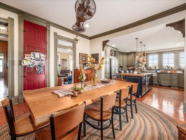 dining room with recessed lighting, wood finished floors, and ornamental molding