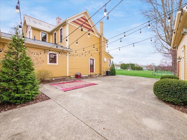 exterior space with central AC unit and a patio