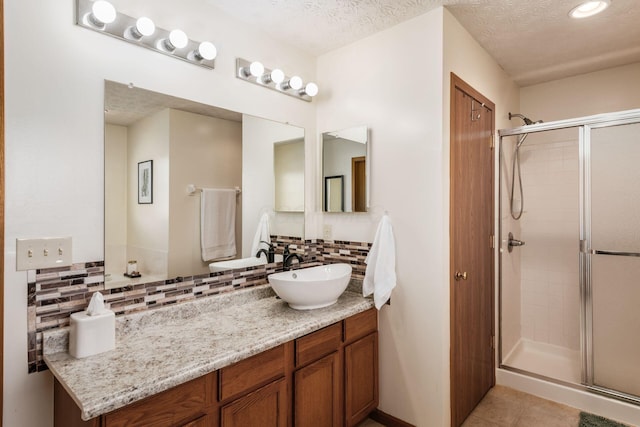 3073 Kola Way, Columbus, OH 43219 - full bathroom with vanity, decorative backsplash, a stall shower, and a textured ceiling