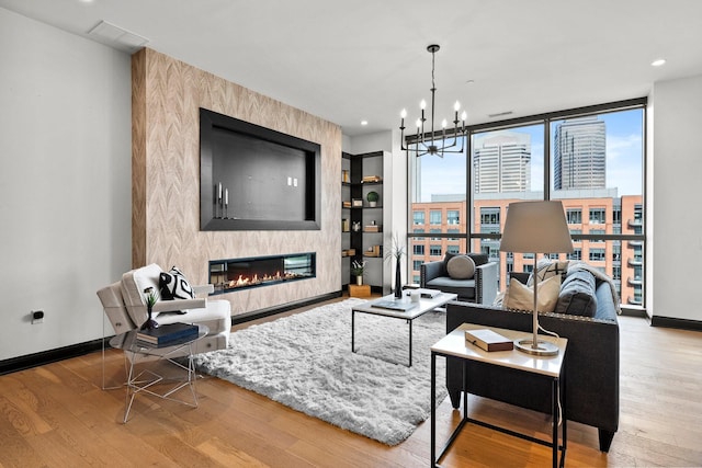 225 John H Mcconnell Blvd Unit 705, Columbus, OH 43215 - living room featuring wood finished floors, an inviting chandelier, baseboards, and a large fireplace