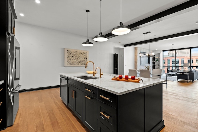 225 John H Mcconnell Blvd Unit 705, Columbus, OH 43215 - kitchen featuring light wood-type flooring, a kitchen island with sink, a sink, stainless steel appliances, and dark cabinetry