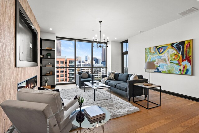 225 John H Mcconnell Blvd Unit 705, Columbus, OH 43215 - living room with visible vents, a notable chandelier, a wall of windows, wood finished floors, and a glass covered fireplace