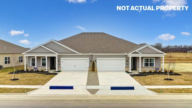 craftsman-style home with concrete driveway, stone siding, a garage, and a front lawn