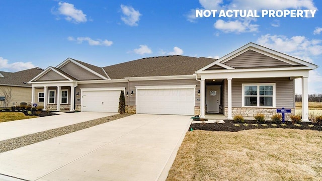 view of front of house with covered porch, a front yard, stone siding, an attached garage, and concrete driveway