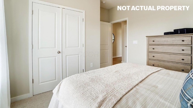 carpeted bedroom featuring a closet and baseboards