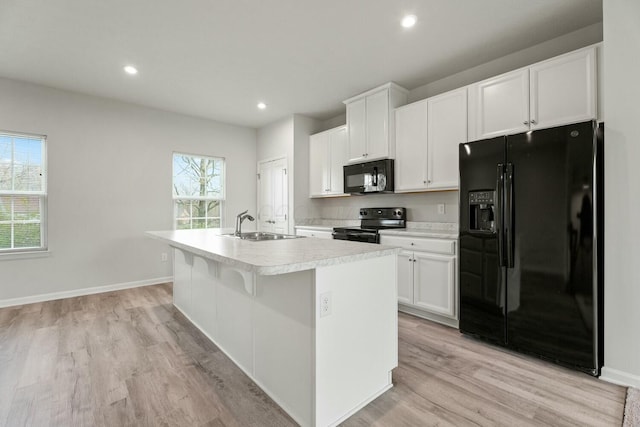 858 Blackcomb Dr, Cincinnati, OH 45244 - kitchen with a sink, light countertops, light wood-style floors, black appliances, and a center island with sink