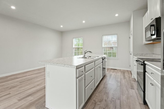 858 Blackcomb Dr, Cincinnati, OH 45244 - kitchen with light wood-type flooring, an island with sink, a sink, and black appliances