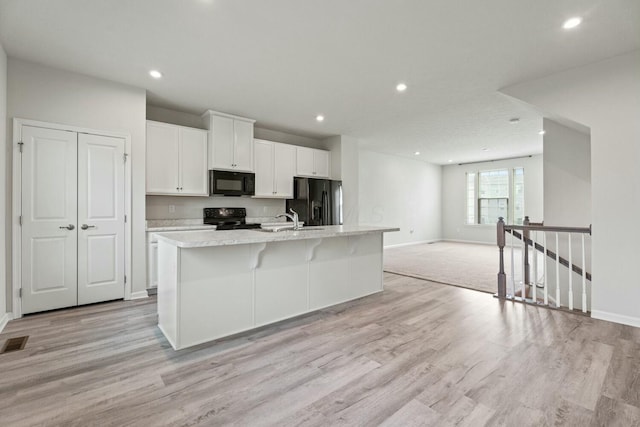 858 Blackcomb Dr, Cincinnati, OH 45244 - kitchen with white cabinetry, black appliances, recessed lighting, and an island with sink