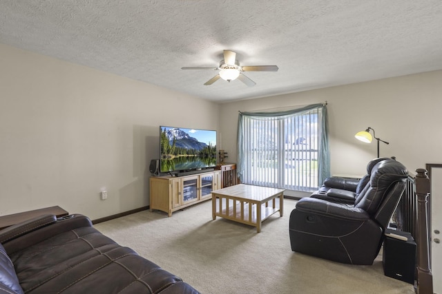 living area with carpet, baseboards, a ceiling fan, and a textured ceiling
