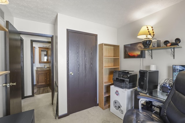home office featuring light carpet, baseboards, visible vents, and a textured ceiling