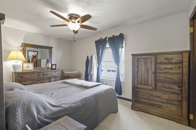 bedroom with baseboards, ceiling fan, light colored carpet, and a textured ceiling