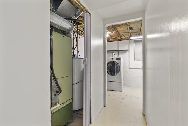 clothes washing area featuring washer / clothes dryer, laundry area, water heater, and concrete block wall
