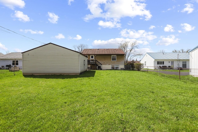 rear view of property featuring a yard and fence