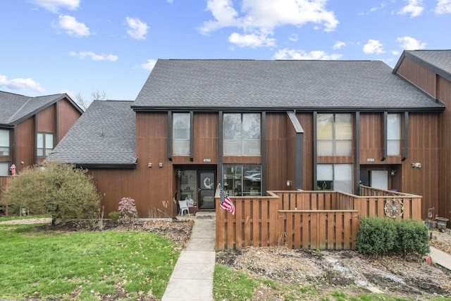 rear view of property featuring a shingled roof