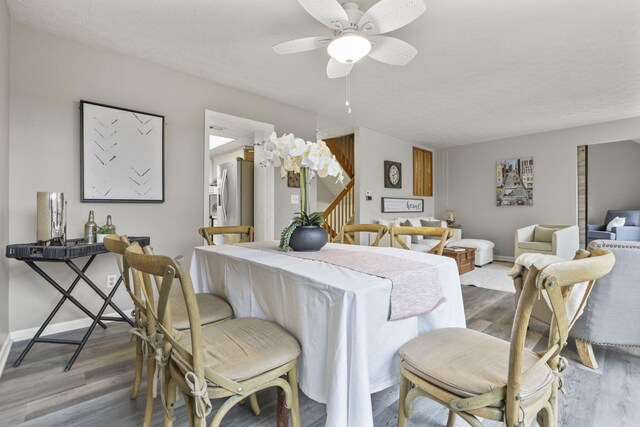 dining room featuring baseboards, a ceiling fan, and wood finished floors