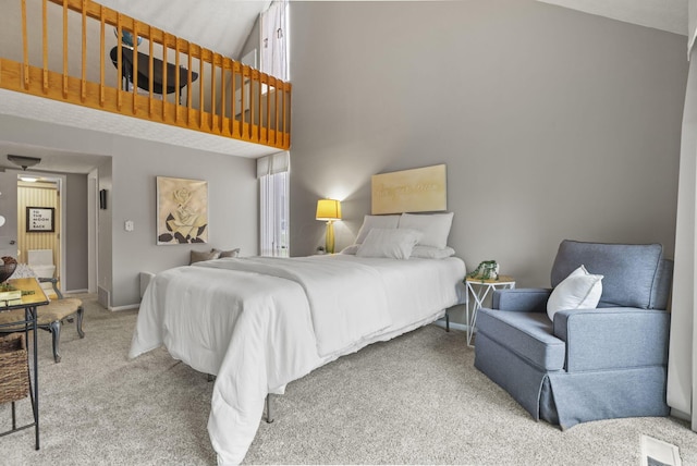 carpeted bedroom featuring a high ceiling and baseboards