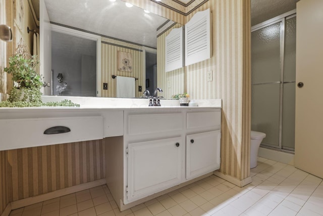 full bathroom featuring toilet, a shower stall, vanity, and wallpapered walls