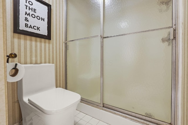 bathroom featuring toilet, tile patterned flooring, a shower with door, and wallpapered walls