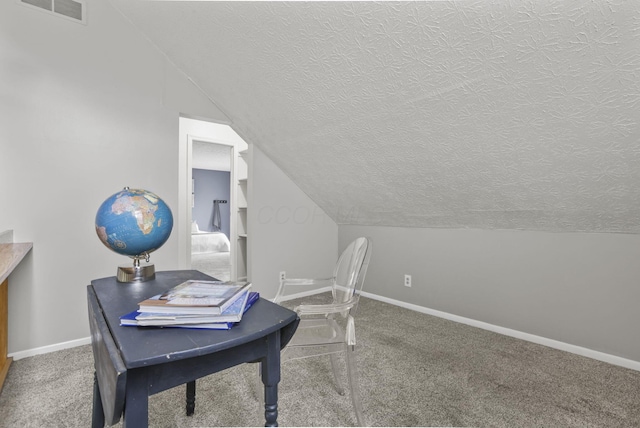carpeted home office featuring visible vents, a textured ceiling, baseboards, and lofted ceiling