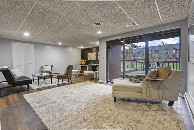 living room featuring visible vents, recessed lighting, a baseboard heating unit, and wood finished floors