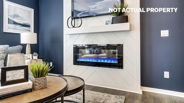 living room with wood finished floors, a fireplace, and baseboards