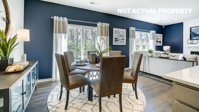 dining space with light wood-type flooring, baseboards, and visible vents