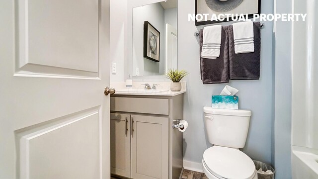 bathroom featuring vanity, a tub, and toilet