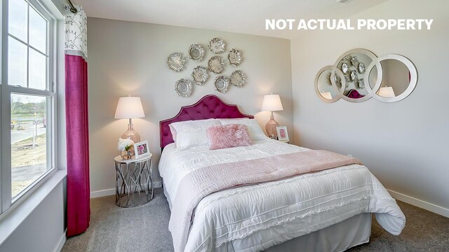 carpeted bedroom featuring multiple windows and baseboards