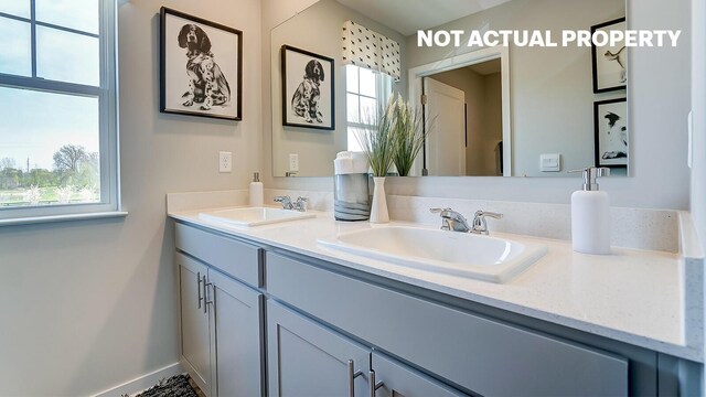 bathroom featuring double vanity, baseboards, and a sink