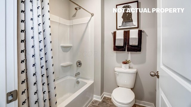bathroom featuring shower / bath combination with curtain, baseboards, and toilet