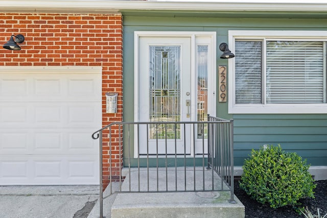 2209 Fishinger Rd, Columbus, OH 43221 - view of exterior entry with a garage and brick siding
