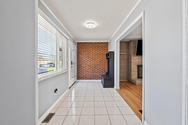 2209 Fishinger Rd, Columbus, OH 43221 - hallway featuring crown molding, light tile patterned floors, brick wall, and visible vents