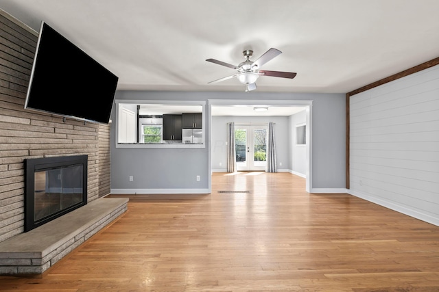 2209 Fishinger Rd, Columbus, OH 43221 - unfurnished living room with baseboards, a ceiling fan, light wood finished floors, and a brick fireplace