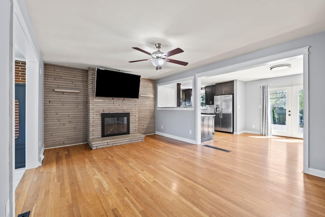 2209 Fishinger Rd, Columbus, OH 43221 - unfurnished living room with a ceiling fan, visible vents, a fireplace, baseboards, and light wood-style flooring
