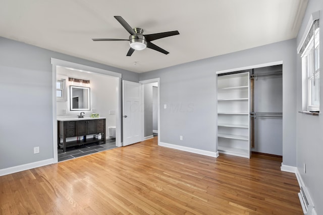 2209 Fishinger Rd, Columbus, OH 43221 - unfurnished bedroom featuring baseboards, a sink, and wood finished floors