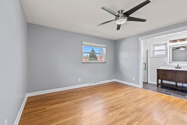 2209 Fishinger Rd, Columbus, OH 43221 - unfurnished bedroom with baseboards, visible vents, multiple windows, and wood finished floors