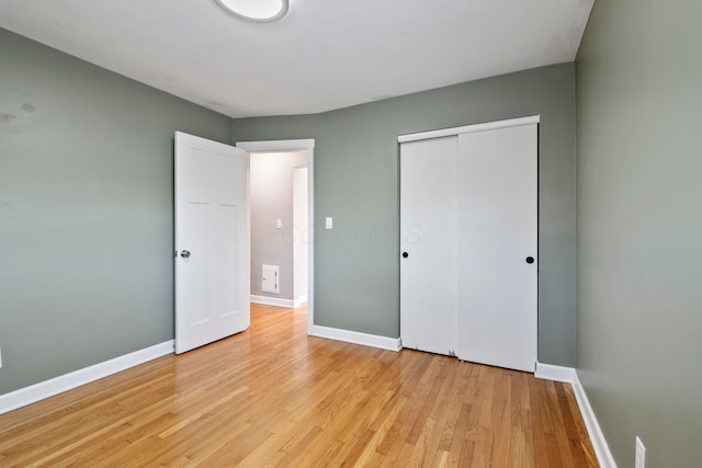2209 Fishinger Rd, Columbus, OH 43221 - unfurnished bedroom with baseboards, a closet, and light wood-style flooring