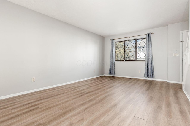 empty room with light wood-style flooring and baseboards
