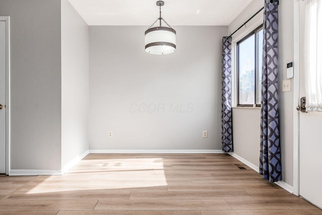 empty room with baseboards, visible vents, and light wood-style flooring