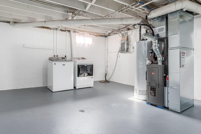 basement with concrete block wall, heating unit, water heater, and washer and clothes dryer