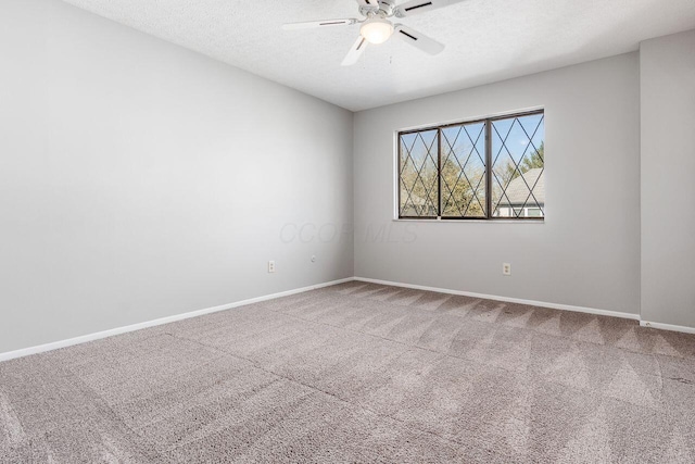 carpeted empty room with a textured ceiling, a ceiling fan, and baseboards