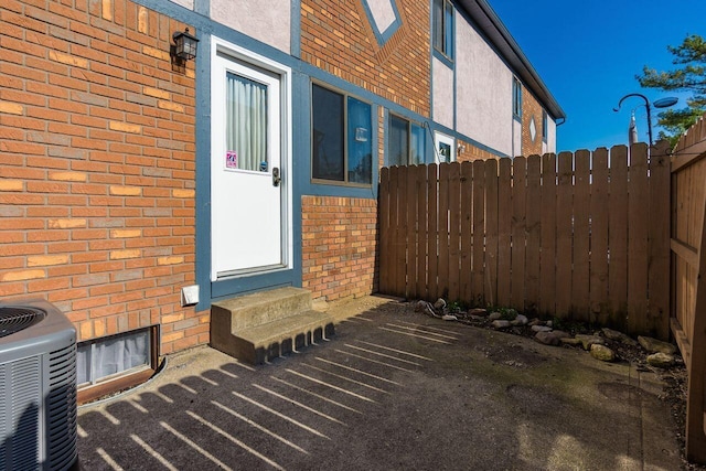 view of patio / terrace featuring fence, entry steps, and central AC