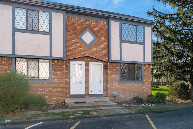 multi unit property with uncovered parking, brick siding, and stucco siding