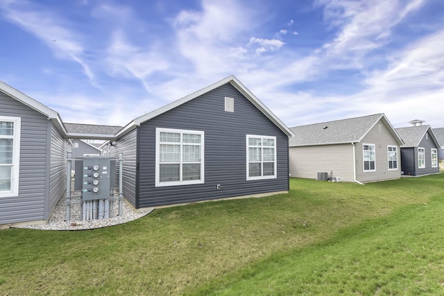 rear view of house featuring a yard and cooling unit