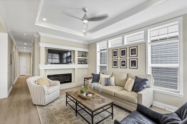 living area featuring baseboards, recessed lighting, crown molding, a ceiling fan, and wood finished floors