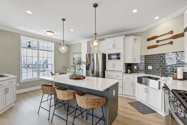 kitchen with stainless steel appliances, tasteful backsplash, a sink, and ornamental molding